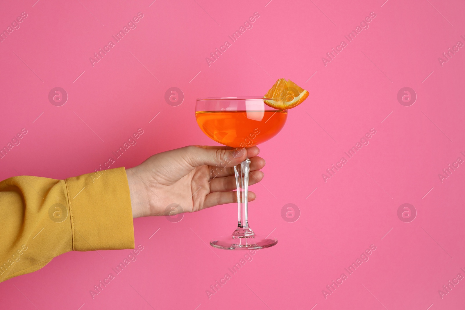 Photo of Woman with glass of refreshing cocktail on pink background, closeup