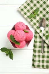 Photo of Scoops of tasty watermelon sorbet with mint in bowl and spoon on white wooden table, flat lay