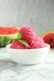 Photo of Scoops of tasty watermelon sorbet with mint in bowl on white marble table