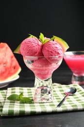 Photo of Scoops of tasty watermelon sorbet with mint, fresh fruit in glass dessert bowl and spoon on wooden table