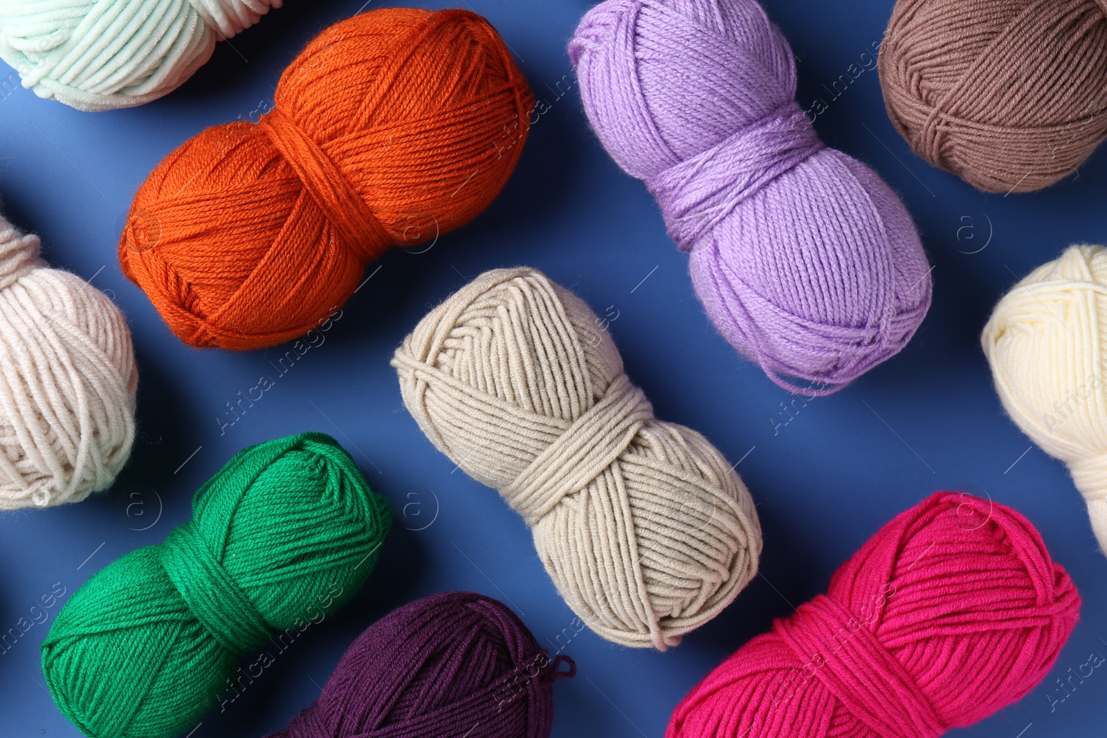 Photo of Different colorful yarns on blue background, flat lay