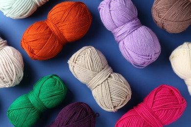 Photo of Different colorful yarns on blue background, flat lay