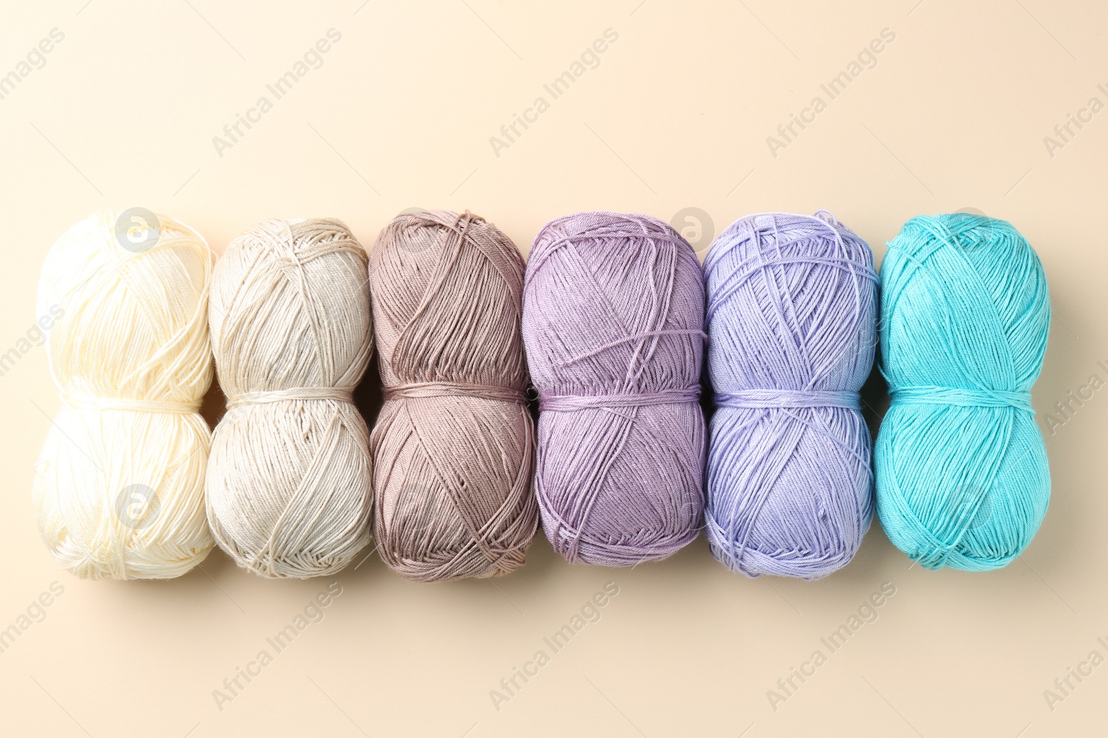 Photo of Different colorful yarns on beige background, flat lay