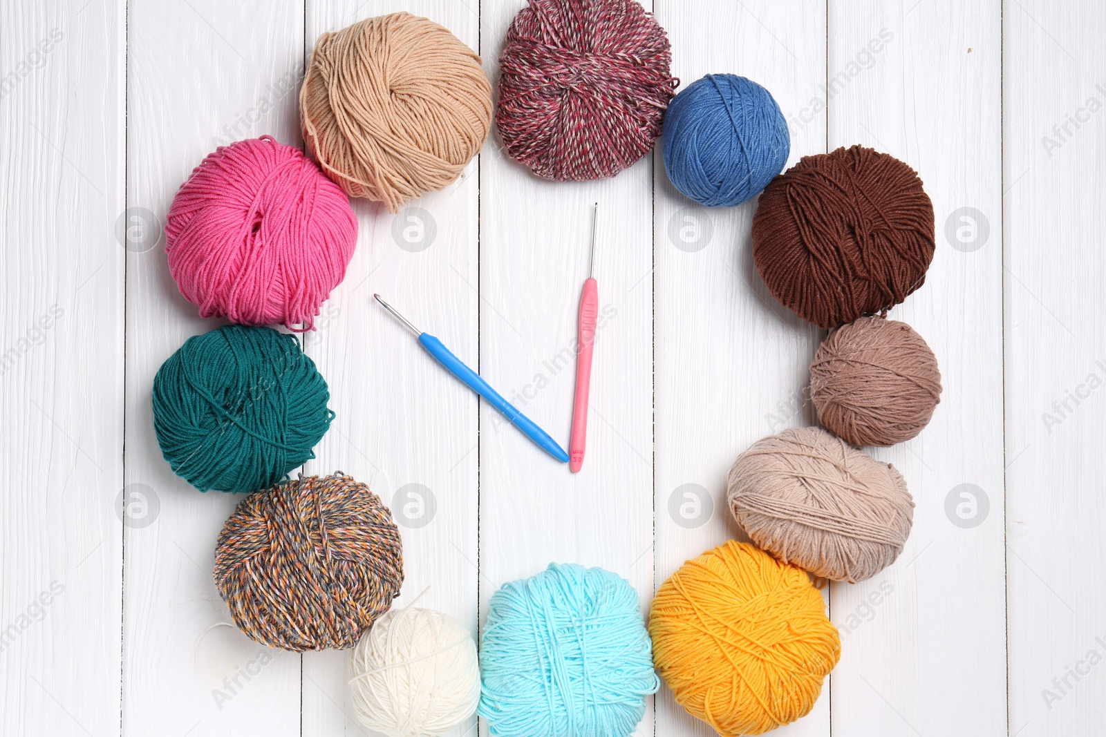 Photo of Clock made of colorful yarns and hooks on white wooden table, flat lay. Time to hobby