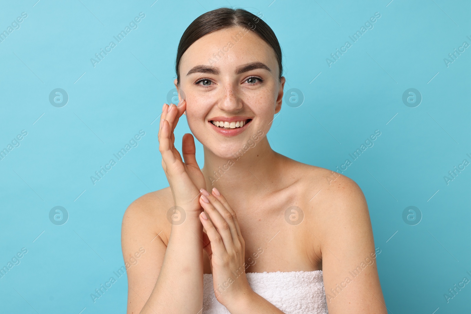 Photo of Beautiful young woman with healthy skin on light blue background