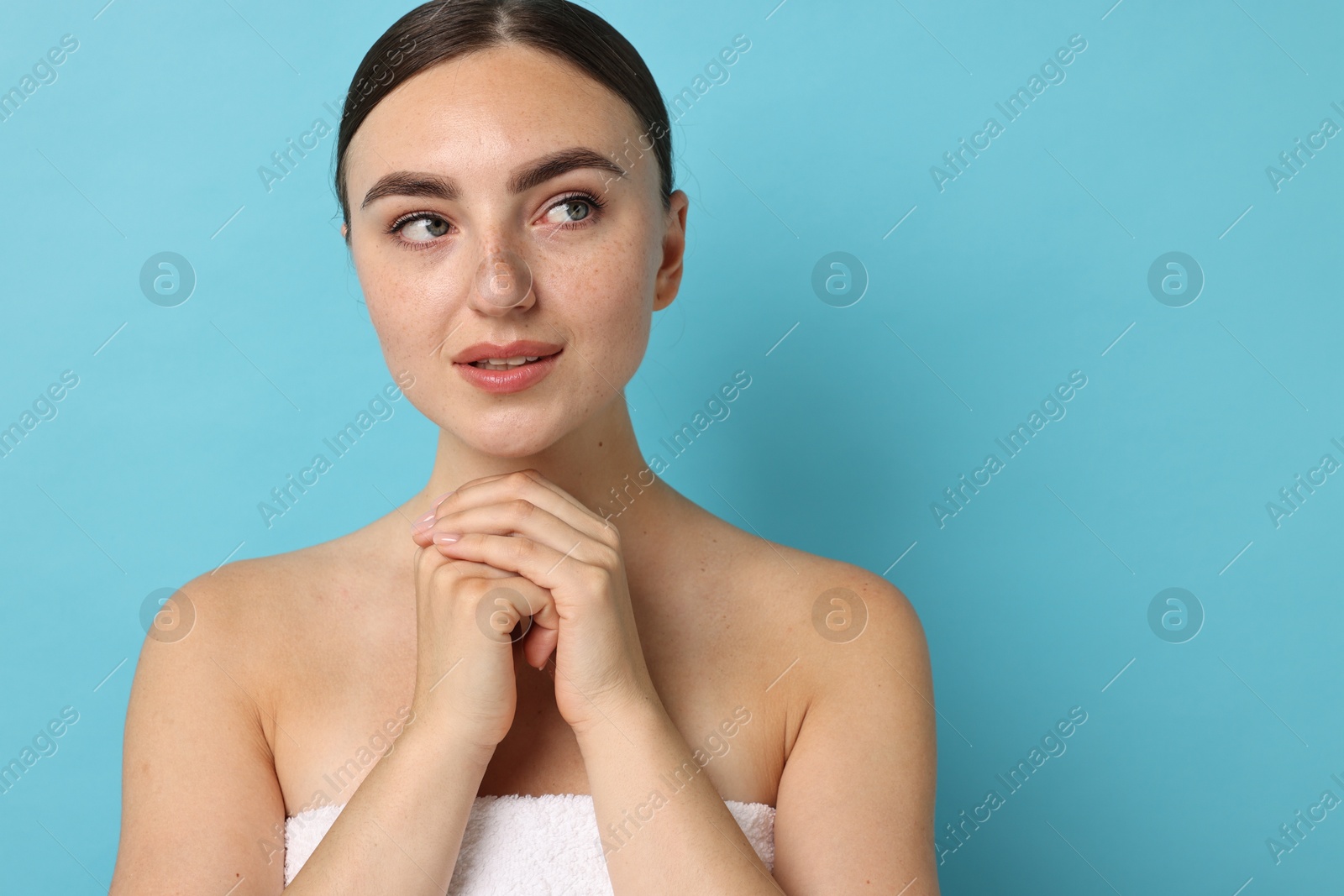 Photo of Beautiful young woman with healthy skin on light blue background, space for text