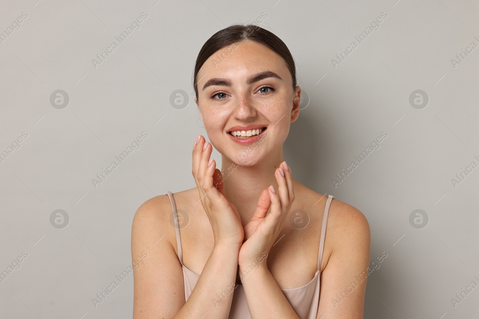 Photo of Beautiful young woman with healthy skin on grey background