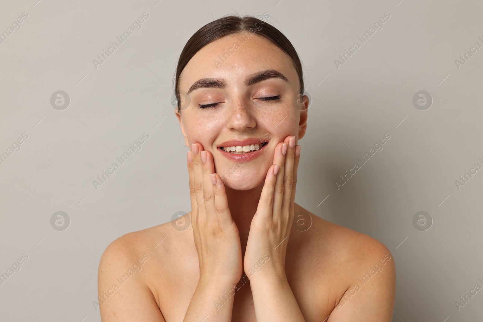 Photo of Beautiful young woman with healthy skin on grey background