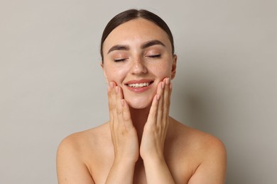 Photo of Beautiful young woman with healthy skin on grey background