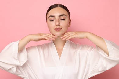 Photo of Face massage. Beautiful young woman with healthy skin on pink background