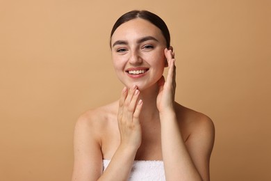 Photo of Face massage. Beautiful young woman with healthy skin on beige background