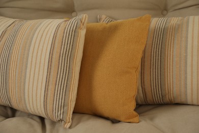 Photo of Soft colorful pillows on sofa at home