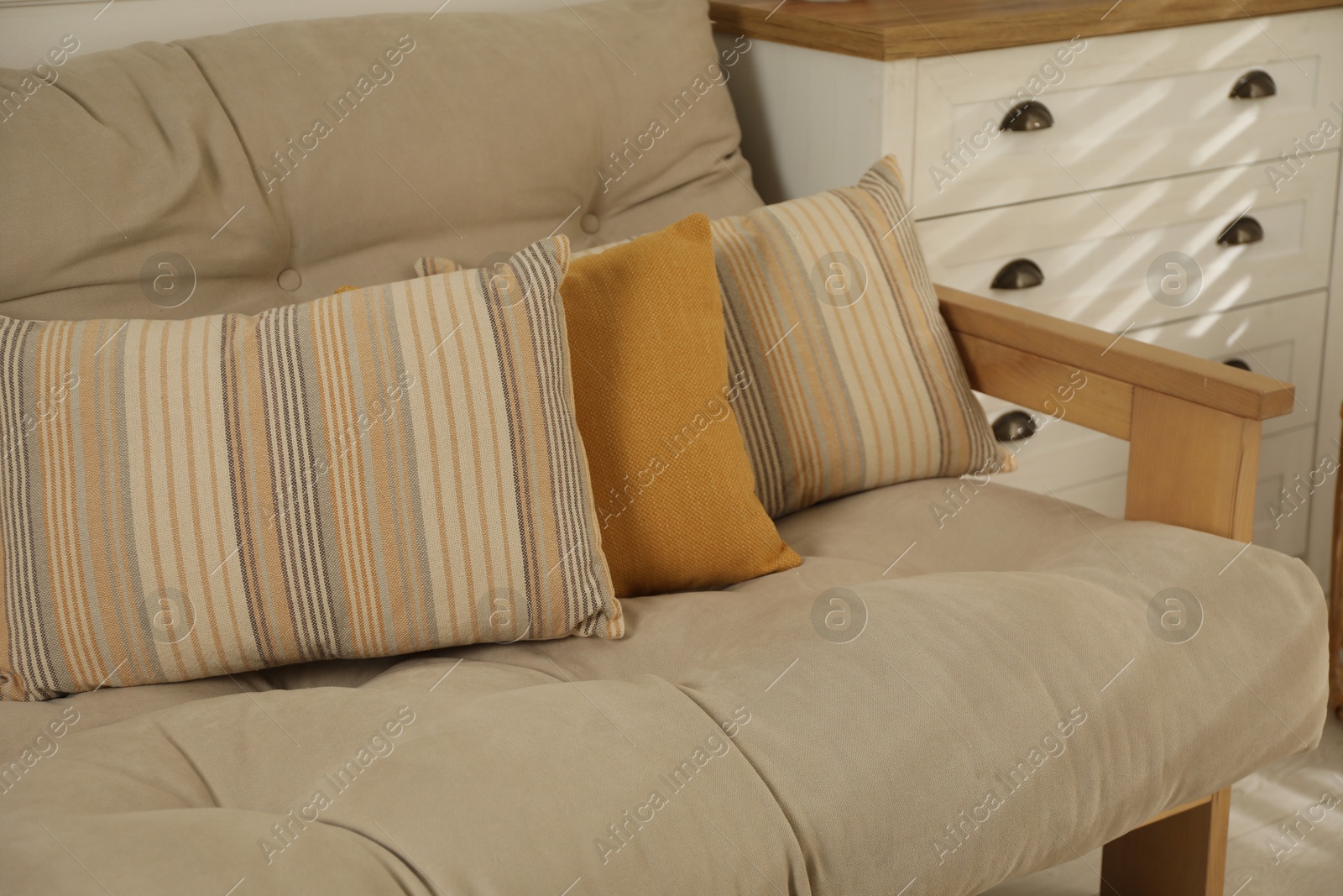 Photo of Soft colorful pillows on sofa at home