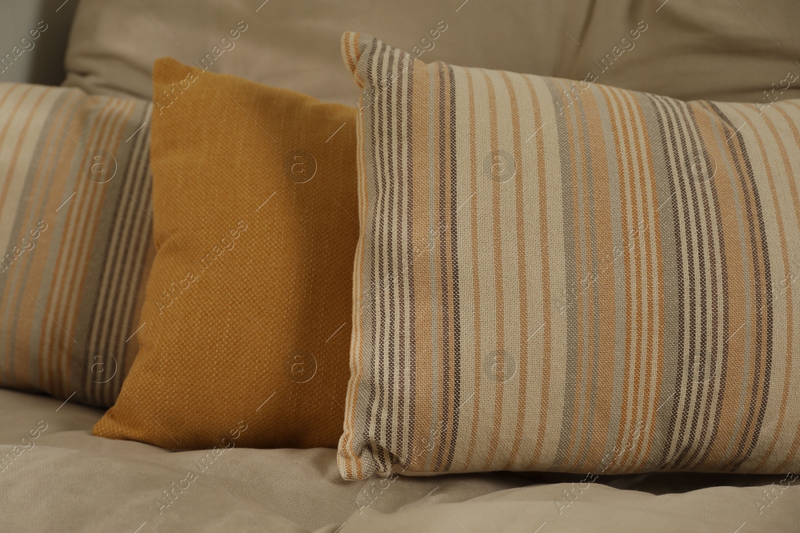 Photo of Soft colorful pillows on sofa at home