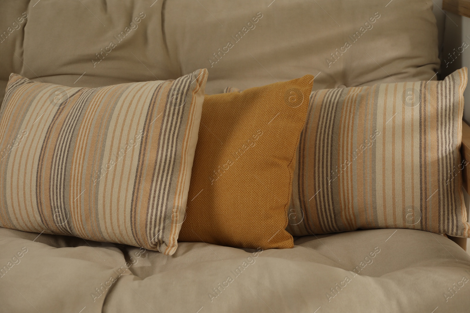 Photo of Soft colorful pillows on sofa at home