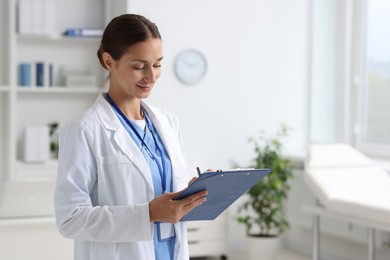 Nurse in medical uniform with clipboard indoors, space for text