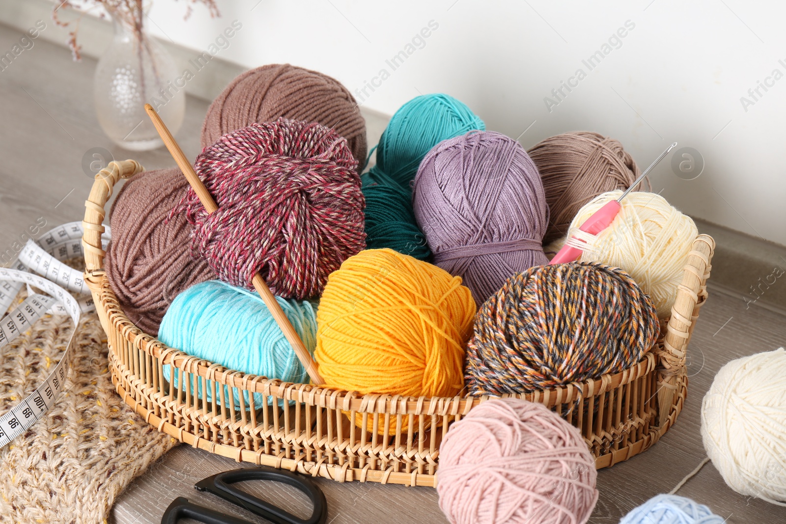 Photo of Different yarns, crochet hooks and other tools on wooden shelf