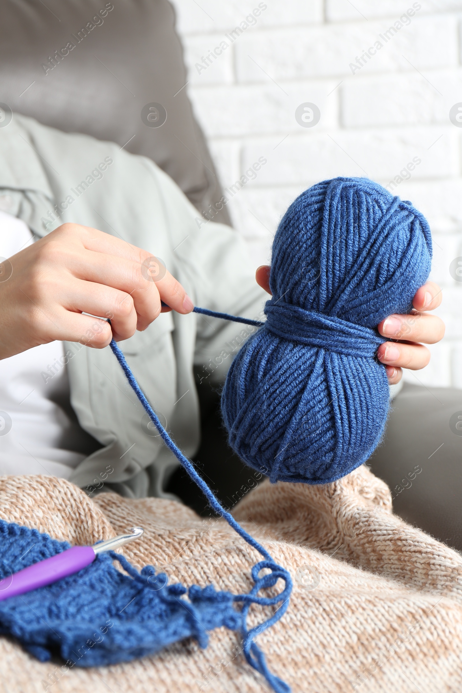 Photo of Woman holding blue yarn at home, closeup