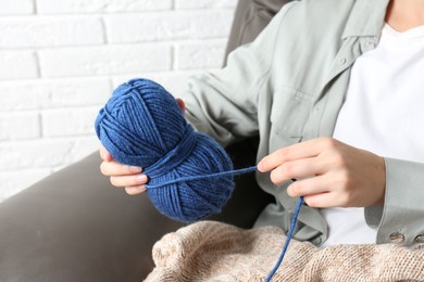 Photo of Woman holding blue yarn at home, closeup