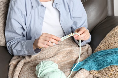 Photo of Woman crocheting with hook and yarn, closeup