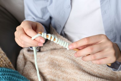 Photo of Woman crocheting with hook and yarn, closeup