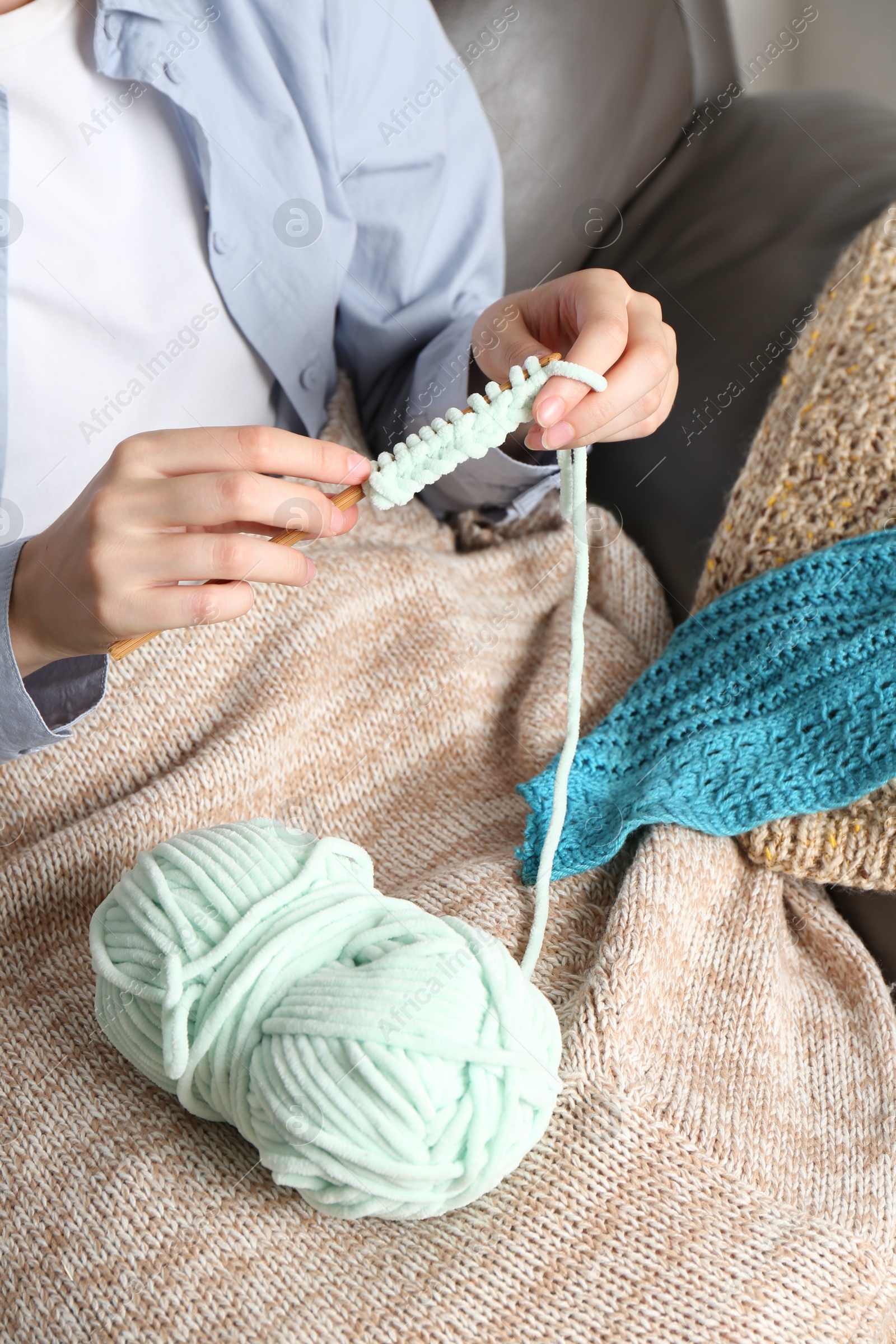 Photo of Woman crocheting with hook and yarn, closeup