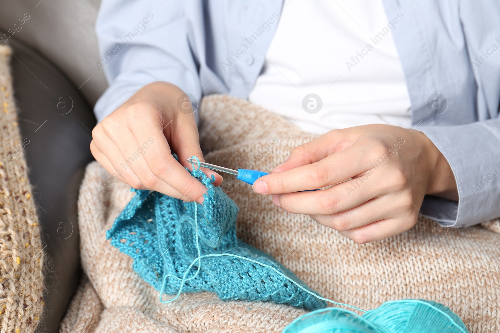 Photo of Woman crocheting with hook and yarn, closeup