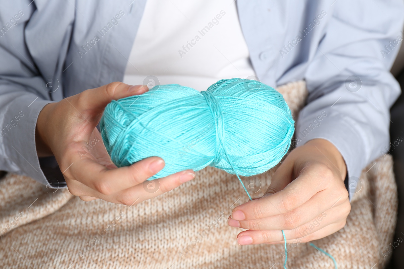 Photo of Woman holding light blue yarn, closeup view