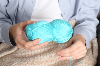 Photo of Woman holding light blue yarn, closeup view