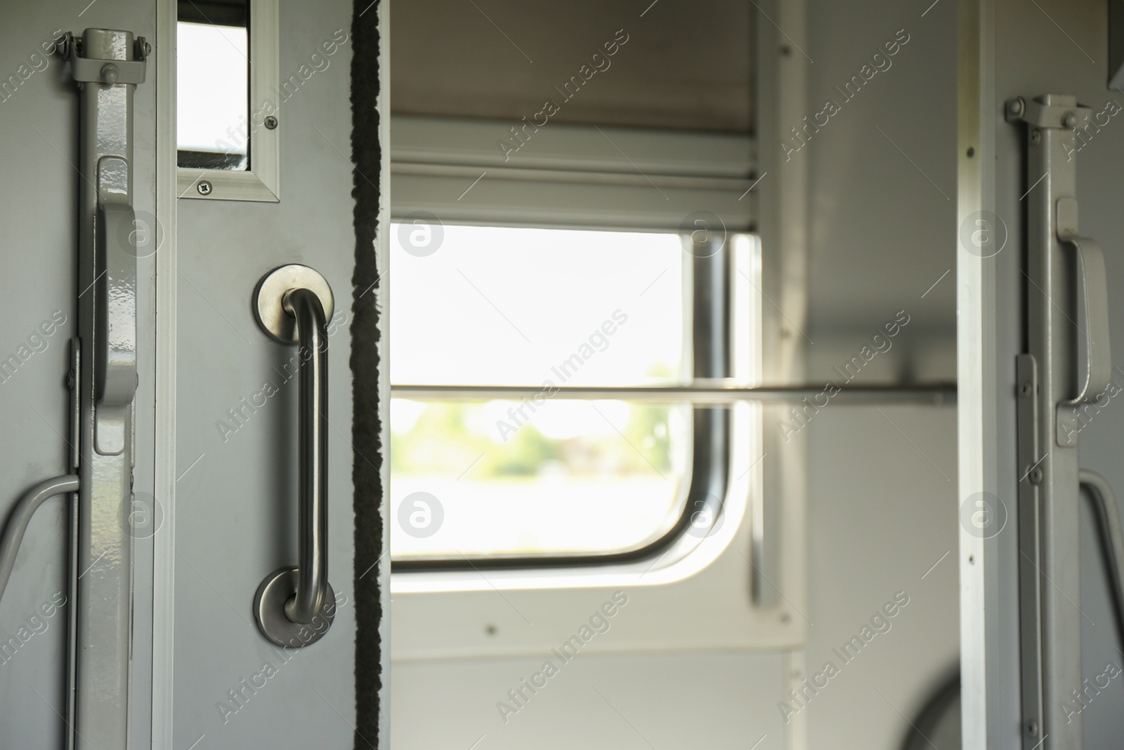 Photo of White compartment door with metal handle in train car, closeup