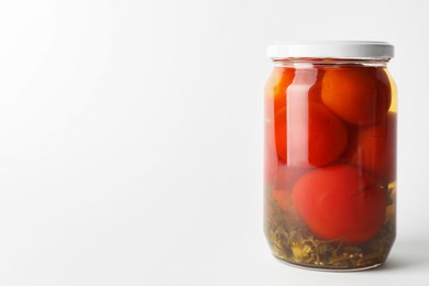 Tasty pickled tomatoes in jar on light grey background. Space for text