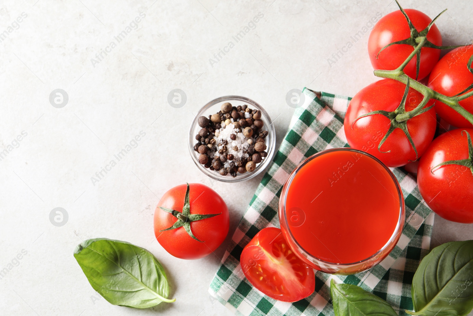 Photo of Tasty tomato juice in glass, spices and fresh vegetables on light table, flat lay. Space for text