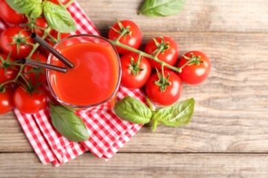 Photo of Tasty tomato juice in glass with fresh vegetables and basil on wooden table, flat lay. Space for text