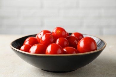 Tasty pickled tomatoes in bowl on light grey table