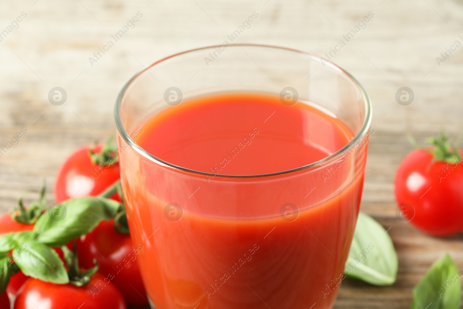 Photo of Fresh tomato juice in glass on table, closeup