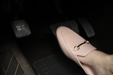 Photo of Woman pushing on pedal of car brake, closeup