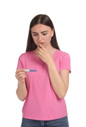 Photo of Confused woman holding pregnancy test on white background