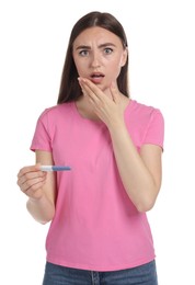 Shocked woman holding pregnancy test on white background