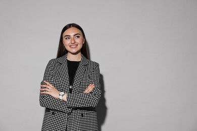 Photo of Beautiful woman in stylish suit on gray background, space for text