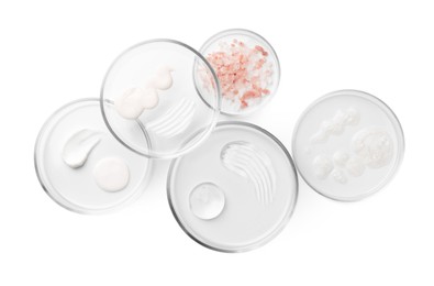 Petri dishes with different cosmetic products and leaves isolated on white, flat lay