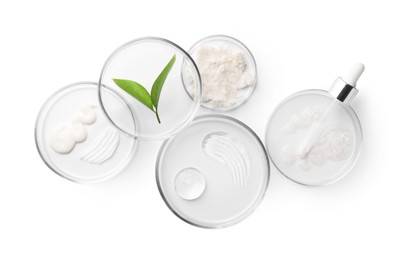 Photo of Petri dishes with different cosmetic products and leaves isolated on white, flat lay