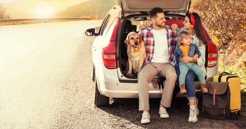 Image of Parents, their daughter and dog sitting in car trunk near road. Banner design with space for text