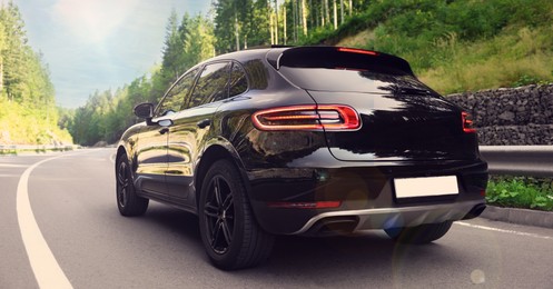 Image of Modern black car on asphalt road outdoors. Banner design