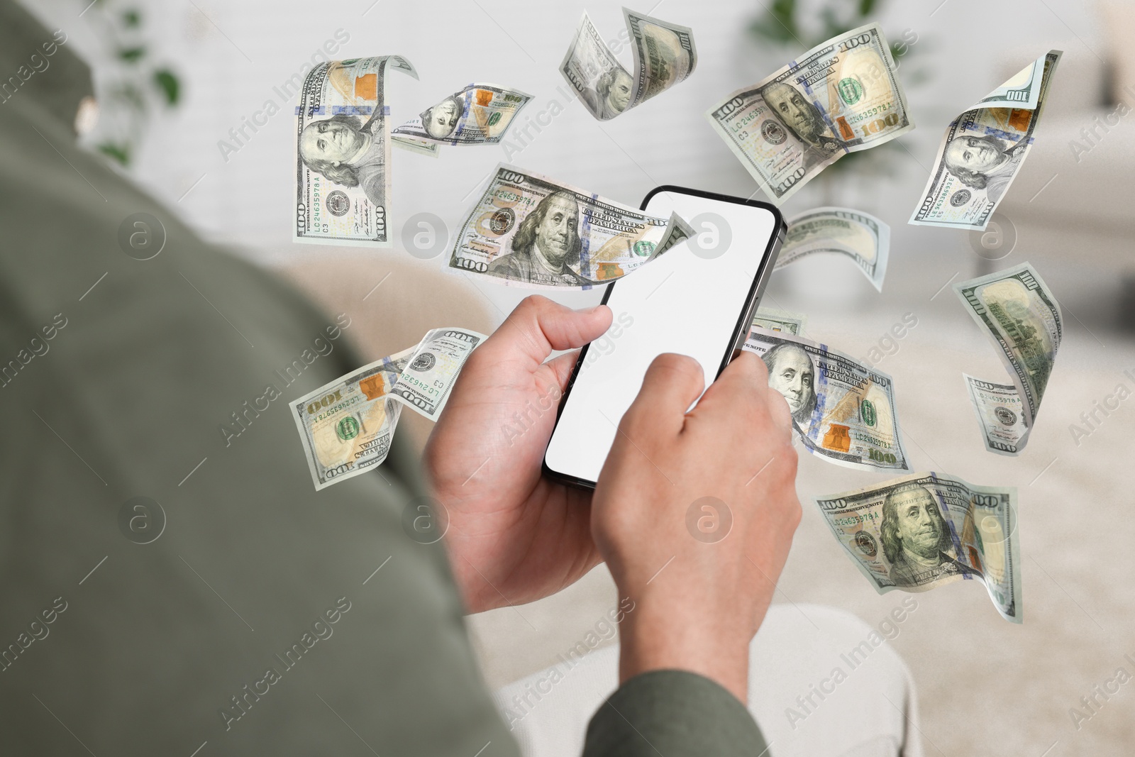 Image of Man using smartphone at home, closeup. Money flying around device