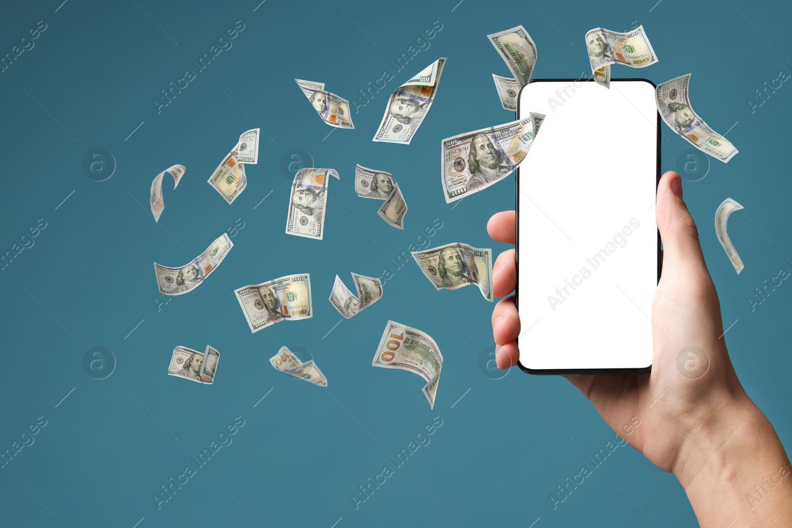 Image of Man holding smartphone with blank screen on light blue background, closeup. Money flying around device