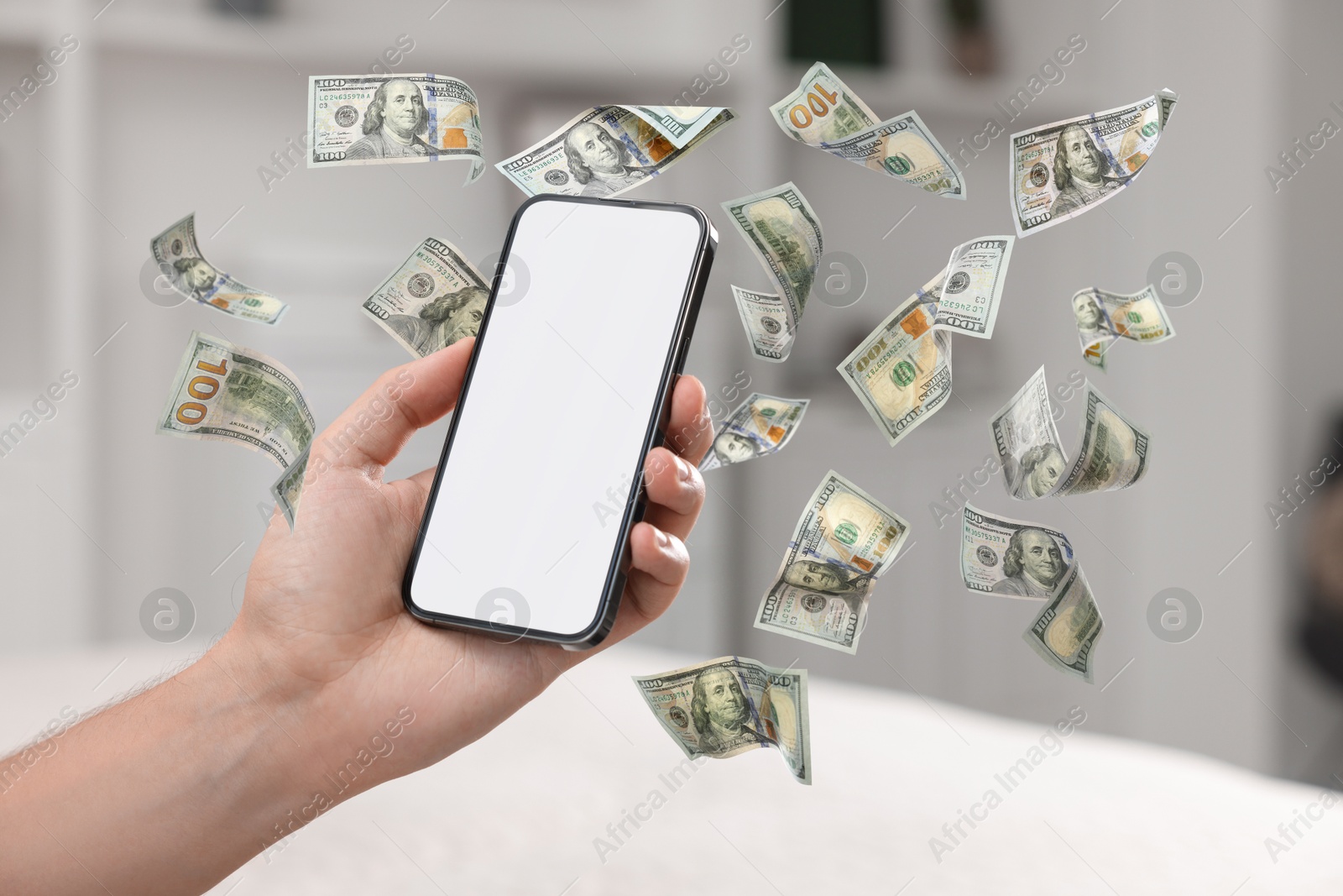 Image of Man using smartphone at home, closeup. Money flying around device