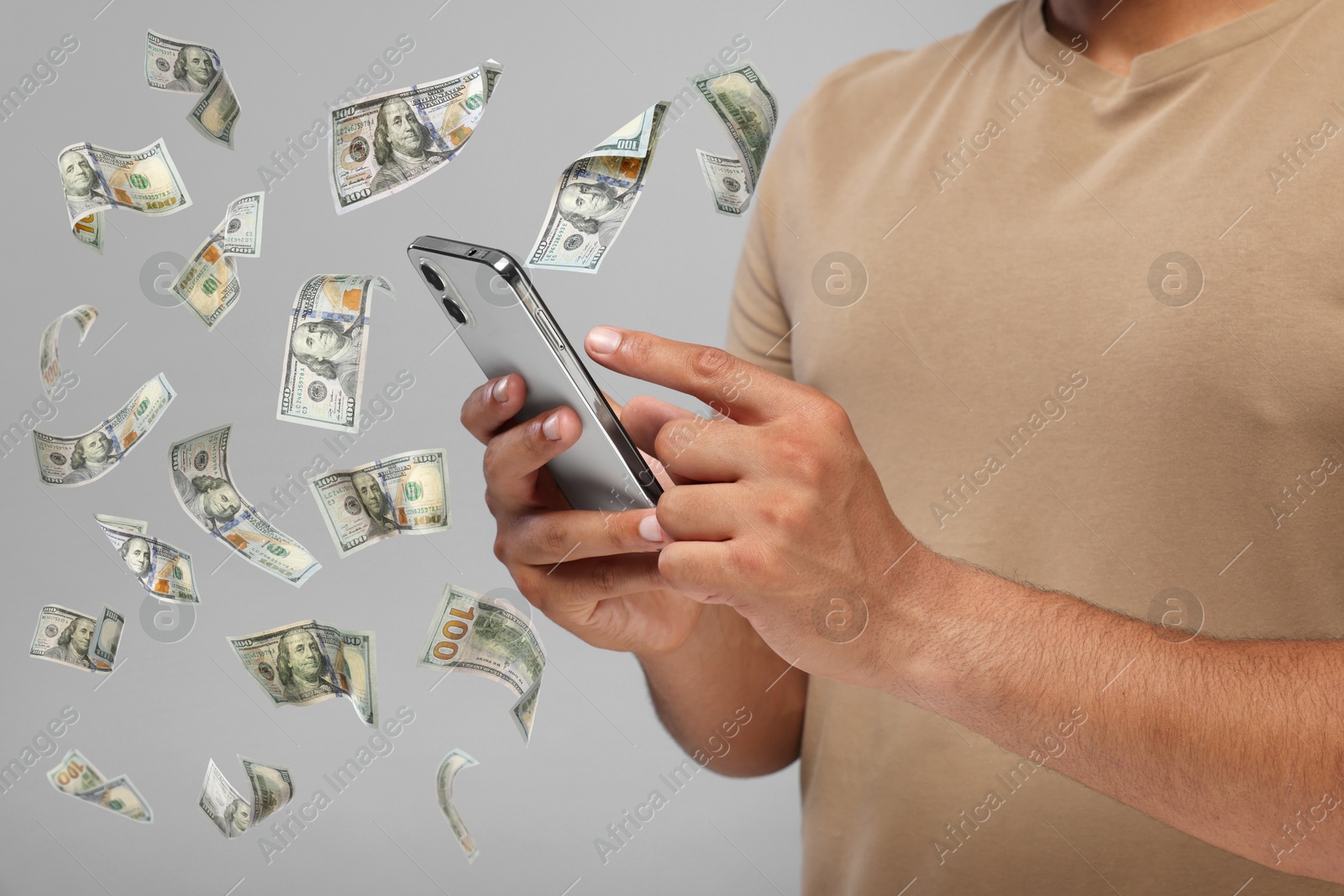 Image of Man using smartphone on light grey background, closeup. Money flying around device