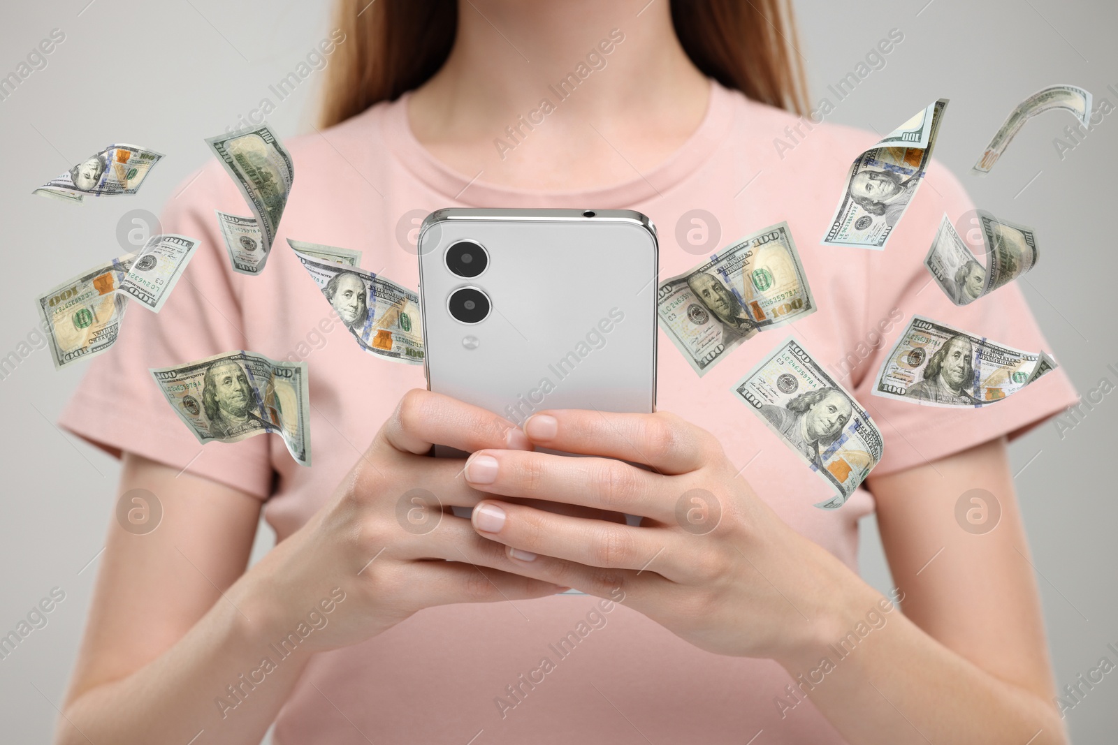 Image of Woman using smartphone on light grey background, closeup. Money flying around device