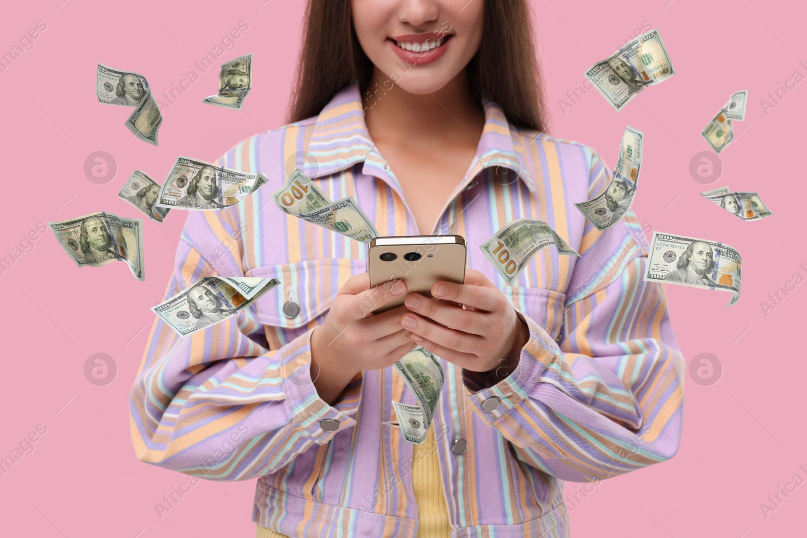 Image of Woman using smartphone on pink background, closeup. Money flying around device