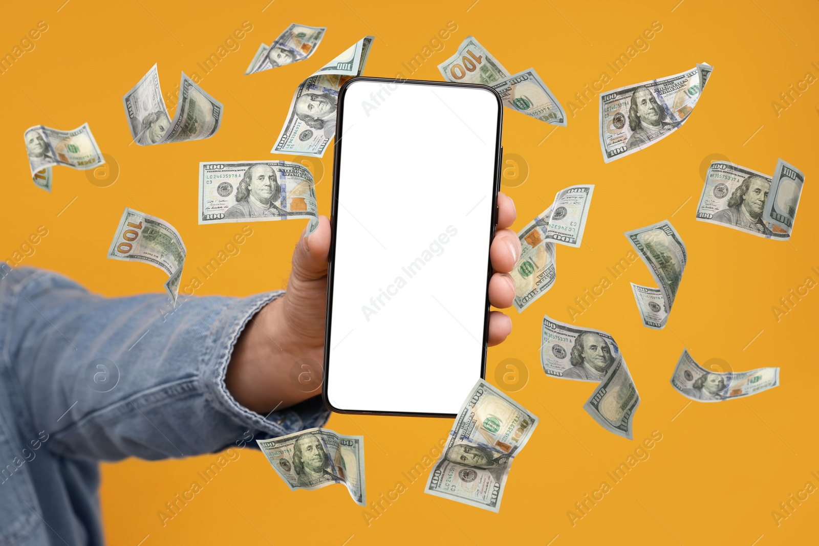 Image of Man showing smartphone with blank screen on orange background, closeup. Money flying around device